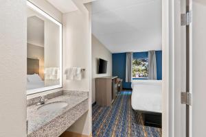 a hotel room with a bathroom with a bed and a sink at Quality Inn & Suites Shepherdstown in Shepherdstown +51 photos