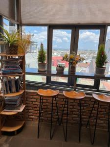 a counter with stools in front of a window with plants at Vindy House in Da Lat