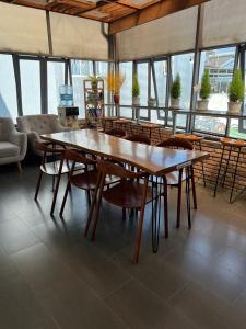 a dining room with tables and chairs and windows at Vindy House in Da Lat
