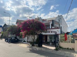 a street with a building with pink flowers on it at Vindy House in Da Lat