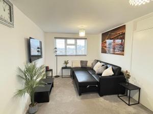 a living room with a black couch and a table at Cosy one bed Flat in Stevenage in Stevenage