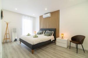 a bedroom with a large bed and a chair at Seaview Villa with Heated Private Pool in Bretanha