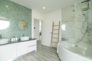 a bathroom with two sinks and a tub and a shower at Seaview Villa with Heated Private Pool in Bretanha +31 photos