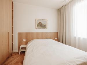 a bedroom with a white bed and a window at Pargimaja in Võru