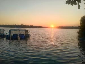 a boat dock on a lake at sunset at Lagoon celebration10 in Perumanseri