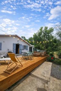 a deck with chairs and tables on a house at KaZen chez Steph in Petite Île