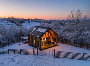 a tiny house in the snow at sunset at Cabana Alpinest & Sauna in Bran