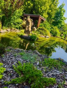a pond in a garden with a house in the background at Penzion u Vodníka in Třeboň
