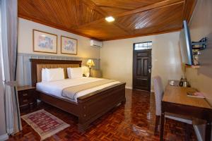 a bedroom with a bed and a desk and a computer at Cozy Stead Hotel - Garden House, Gigiri in Nairobi +137 photos