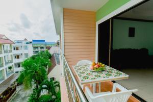a balcony with a table with a bowl of fruit on it at RK Guesthouse in Patong Beach