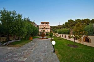 a garden with a building in the background at Seydnaya Apartments & Studios in Neos Marmaras