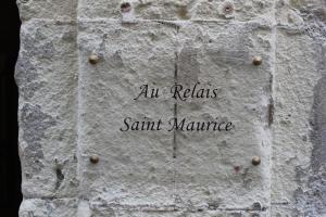 a sign on a brick wall at Au Relais Saint Maurice in Chinon