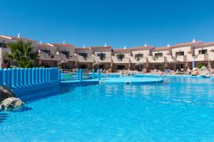Una gran piscina con agua azul en un complejo turístico. en Apartamentos Moon Dreams Los Lentiscos, en Cala en Blanes