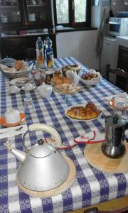 - une table avec un chiffon de table bleu et blanc et une bouilloire dans l'établissement Casa Ramonda, à Neive