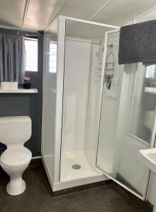 a white bathroom with a shower and a toilet at Jack's Backpackers in Blenheim +33 photos