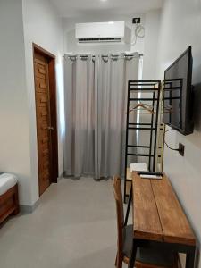 a room with a desk and a television and a ladder at Elisha's Guest House in Coron