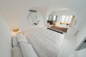 a white bed in a room with a mirror at Villa Kahina in Carthage