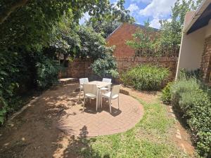 a table and chairs sitting on a brick patio at Spacious & serene townhouse getaway in Bloemfontein +2 photos