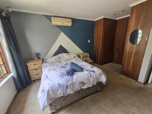 a bedroom with a bed with a purple comforter at Spacious & serene townhouse getaway in Bloemfontein