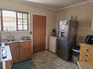 a kitchen with a refrigerator and a sink at Spacious & serene townhouse getaway in Bloemfontein
