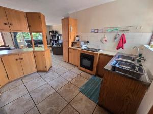 a kitchen with wooden cabinets and a sink at Spacious & serene townhouse getaway in Bloemfontein