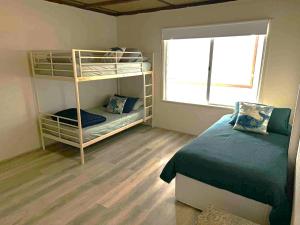 a bedroom with two bunk beds and a window at Cervantes Beach Shack in Cervantes