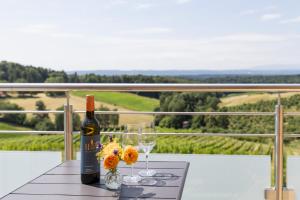 a bottle of wine and two glasses on a table at Weinhof Reichmann in Sankt Peter am Ottersbach +26 photos