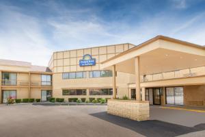 ein Bürogebäude mit einem Schild auf der Vorderseite in der Unterkunft Days Inn & Suites by Wyndham Madison Heights MI in Madison Heights