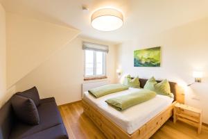 a bedroom with a bed and a couch at Weinhof Reichmann in Sankt Peter am Ottersbach