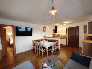 a living room and kitchen with a table and chairs at Jagerhof in Walchsee