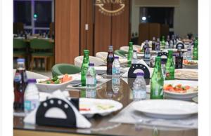 a long table with bottles and plates of food at فندق سويت فيو in Al‘Āriḑah