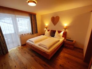 a bedroom with a bed with a heart on the wall at Jagerhof in Walchsee