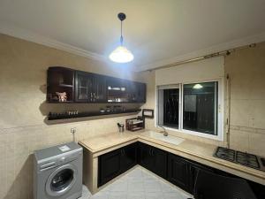 a kitchen with a washing machine and a window at appartement 1 centre ville in Kenitra