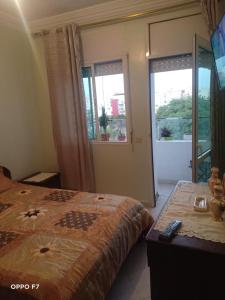 a bedroom with a bed and a television and a window at appartement 1 centre ville in Kenitra