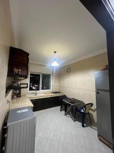 a kitchen with a refrigerator and a table and chairs at appartement 1 centre ville in Kenitra +7 photos