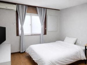 a bedroom with a white bed and a window at Seoraksan Youth Hostel in Sokcho +48 photos