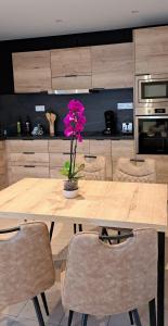 a wooden table with a flower in a vase on it at L'Instant Loire in Saumur +22 photos
