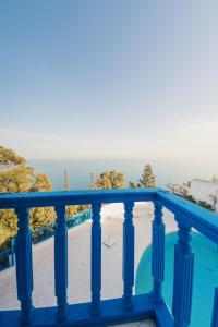 a blue balcony with a view of the ocean at Villa Kahina in Carthage