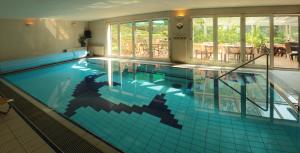 a large swimming pool with blue tiles in a building at Cezar Naturyzm Bielsko-Biała in Bielsko-Biała