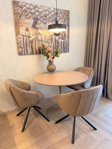 ein Tisch mit zwei Stühlen und eine Vase mit Blumen in der Unterkunft Pine Forest Residence in Melnragė + 16 Fotos