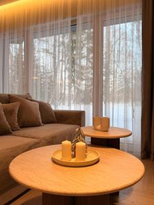 ein Wohnzimmer mit zwei Tischen und einem Sofa in der Unterkunft Pine Forest Residence in Melnragė