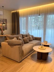 ein Wohnzimmer mit Sofa und Tisch in der Unterkunft Pine Forest Residence in Melnragė