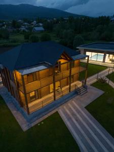 a large wooden cabin with a deck and a house at Homma Aparan with Superpool, 30 min from Yerevan in Aparan