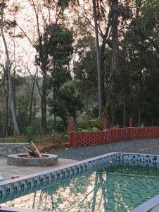 a swimming pool in front of a yard with trees at The Cool Cottage, Pool Extra, at gaya3farms in Palakkad +20 photos