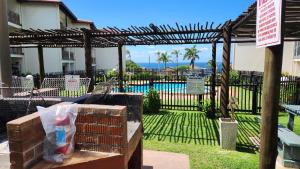 a wooden pergola with a fence and a pool at Topanga 31 in Margate