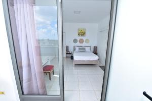 a bedroom with a bed and a window at Hyacinth Golf& Sea in Grand-Baie