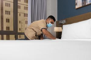 a man in a mask standing next to a bed at MADEN Taiba HOTEL in Medina