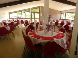 a banquet hall with tables and red chairs at Les Aveilles in La Motte-dʼAveillans
