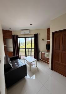 a living room with a couch and a table at Phratamnak Grand Apartments - Cozy Beach in Pattaya South