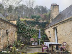 an outdoor patio with a table and an umbrella at La Chambre Périgourdine in Journiac